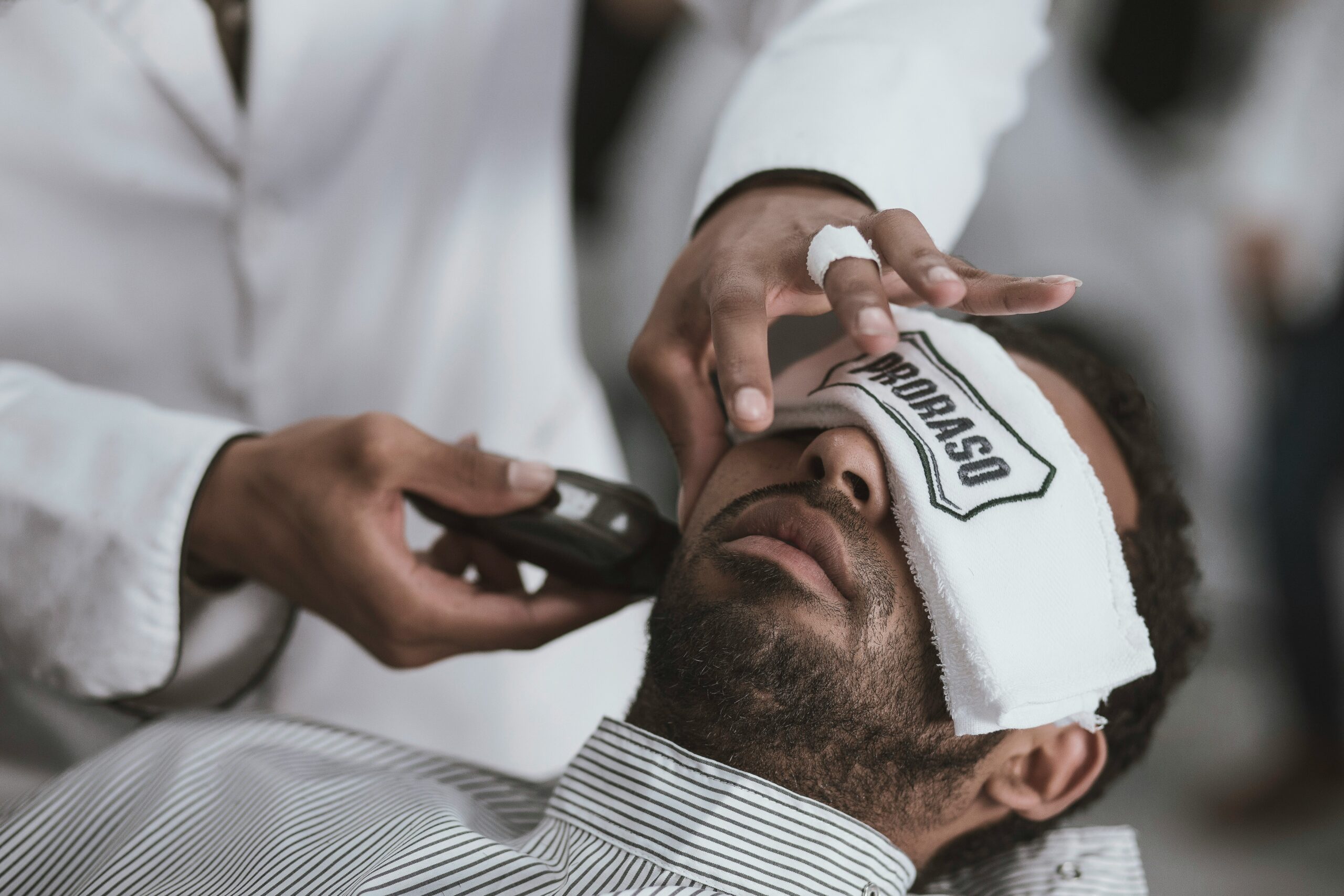 Shape and Line-Up for a Polished Look | T. Benjamin's Barber Shop & Shave Parlor A barber shaping and trimming a client’s beard with precision tools
